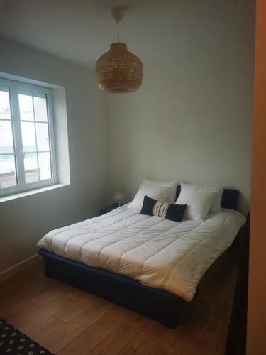 un lit assis dans une pièce avec une fenêtre dans l'établissement Villa Ma-Oé, à L'Aiguillon-la-Presqu'île