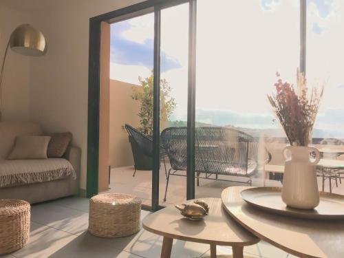 un salon avec un canapé, une table et des chaises dans l'établissement Résidence Le Vénusia, à Port-Vendres