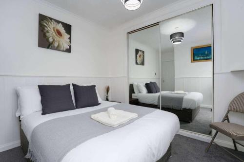 a bedroom with a large white bed and a mirror at 2-Bed Flat Wishaw Free Parking Family-Friendly in Wishaw