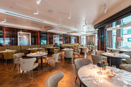 a restaurant with tables and chairs in a room at Crowne Plaza Bahrain by IHG in Manama