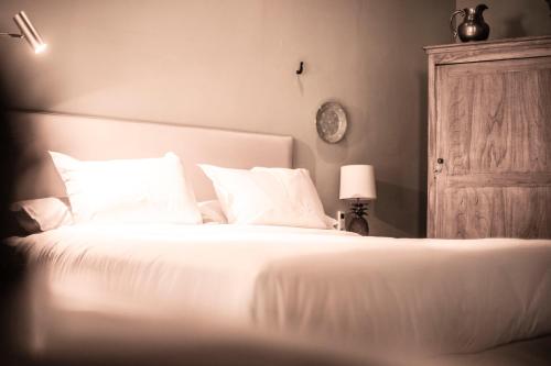 a bed with white sheets and pillows in a bedroom at Casa La Lilia - Villa María Hotel in San Bernardino