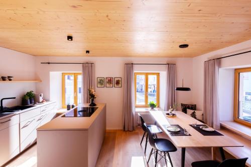 a kitchen with a wooden ceiling and a table with chairs at Apartments Bären in Elzach