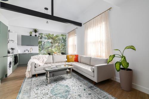 a living room with a white couch and a table at Stylish 2 bed with AC Battersea Park & Power Station, USA Embassy in London