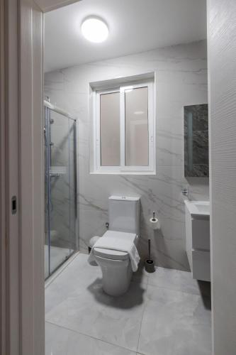 a white bathroom with a toilet and a sink at Stunning 2BR Apartment in Sliema - APT 23 in Sliema