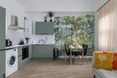 a kitchen and living room with a table and chairs at Stylish 2 bed with AC Battersea Park & Power Station, USA Embassy in London