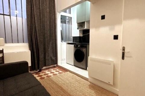 un salon avec une porte menant à une cuisine dans l'établissement Cosy renovated Studio République, à Paris