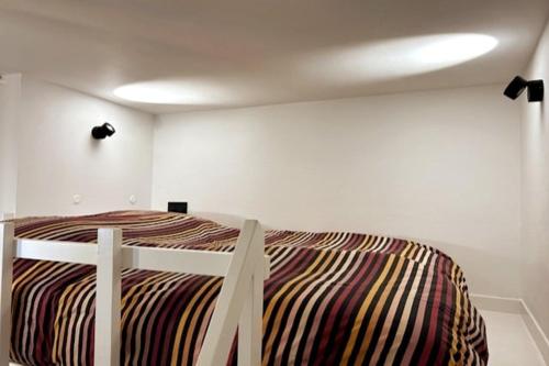 une chambre avec un lit dans une pièce blanche dans l'établissement Cosy renovated Studio République, à Paris