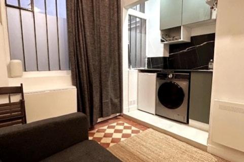 - une cuisine avec un lave-linge dans le salon dans l'établissement Cosy renovated Studio République, à Paris