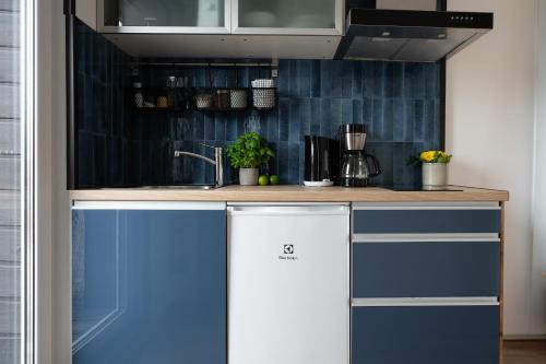 a kitchen with blue and white cabinets and a sink at 4 Bedroom House with Playground, BBQ & Free Parking in Rīga
