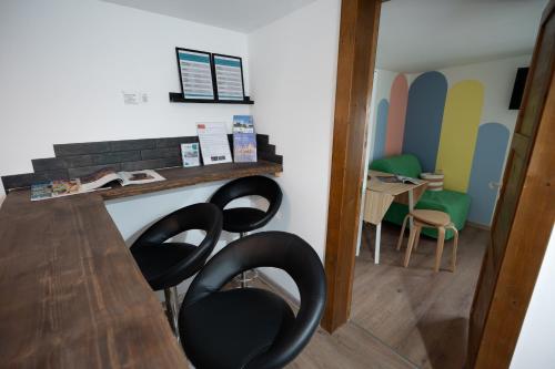 a room with two black chairs and a table at 4 Bedroom House with Playground, BBQ & Free Parking in Rīga