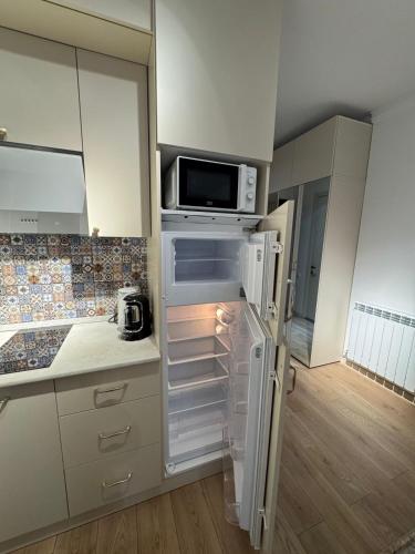 a kitchen with a refrigerator and a microwave at Moonlight Apart-Hotel Batumi in Batumi