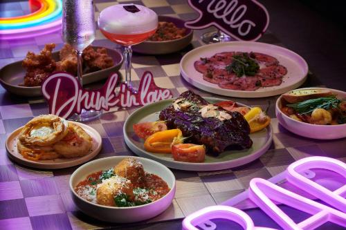 a table with plates of food on a table at Moxy Seoul Myeongdong in Seoul