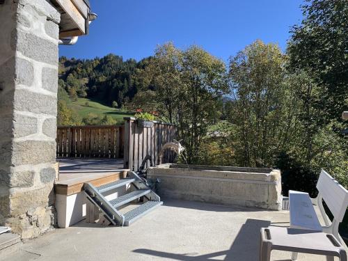 d'une terrasse avec 2 chaises blanches et une clôture en bois. dans l'établissement Chalet Le Char, à La Giettaz