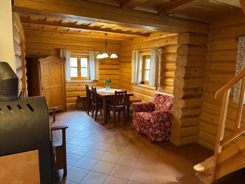 a dining room with a table and chairs in a log cabin at Pension Tereza & Šumavské Roubenky in Sušice