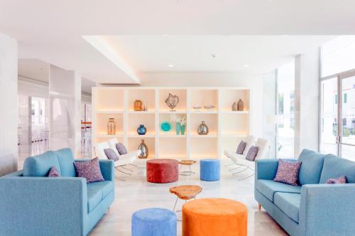 a living room with two blue couches and a table at MarSenses Puerto Pollensa Hotel & Spa Adults Only in Port de Pollensa