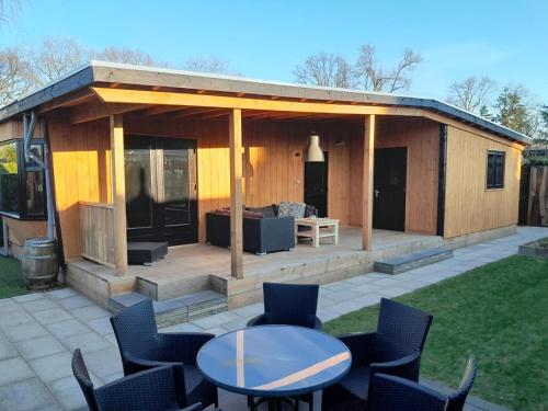 a pavilion with a table and chairs in a yard at Voorts Broekhuisje 5 in Voorthuizen