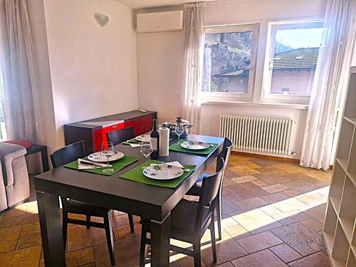 a dining room with a table and chairs and a window at La casa di Maras - Holiday Home Garda Trentino in Nago-Torbole