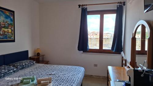 a bedroom with a bed and a window at Bed and Breakfast La Reale in Stintino
