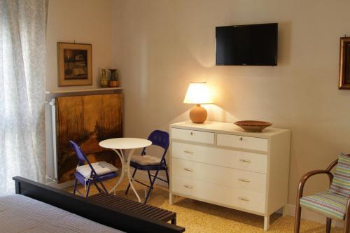 a bedroom with a bed and a dresser with a table and chairs at B&B I Propilei di San Girolamo in Rimini