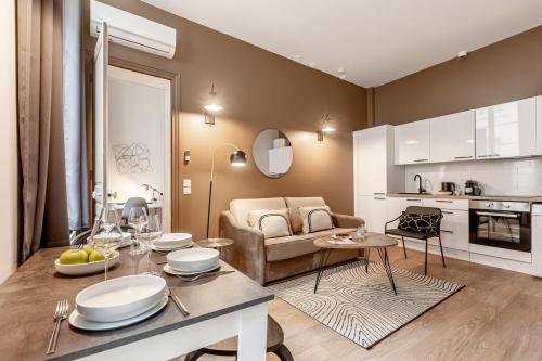 une cuisine et un salon avec une table et un canapé dans l'établissement A11#RépubliqueMarais1BedRoomParis03AC, à Paris