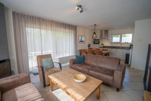 a living room with a couch and a table at Vakantiehuis Hoogelandt 134 en 134a in De Koog