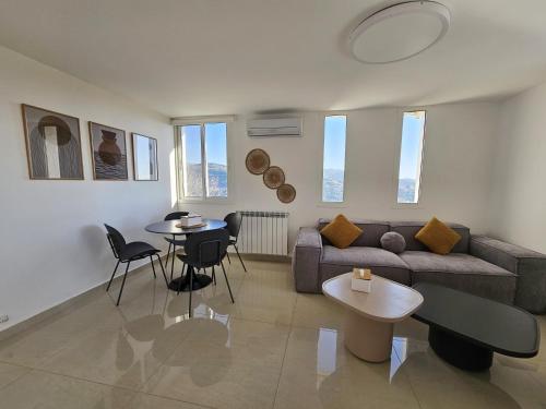 a living room with a couch and a table and chairs at Beit Mema in Aḑ Ḑahr