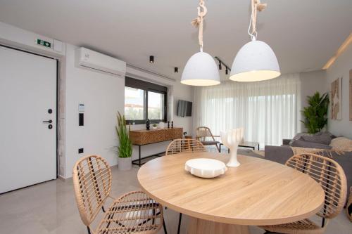 ein Wohnzimmer mit einem Holztisch und Stühlen in der Unterkunft Petrino Complex Pefkohori by Halkidiki Villas in Pefkohori