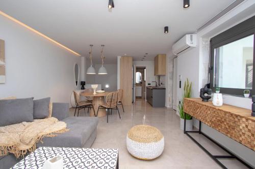 ein Wohnzimmer mit Sofa und Tisch in der Unterkunft Petrino Complex Pefkohori by Halkidiki Villas in Pefkohori