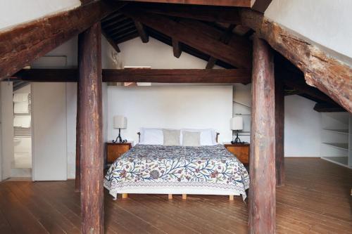 an attic bedroom with a large bed with wooden beams at Palazzo Contarini Della Porta Di Ferro in Venice