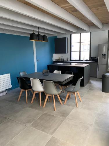 une salle à manger avec une table et des chaises dans une cuisine dans l'établissement Restored loft in Trouville, à Trouville-sur-Mer