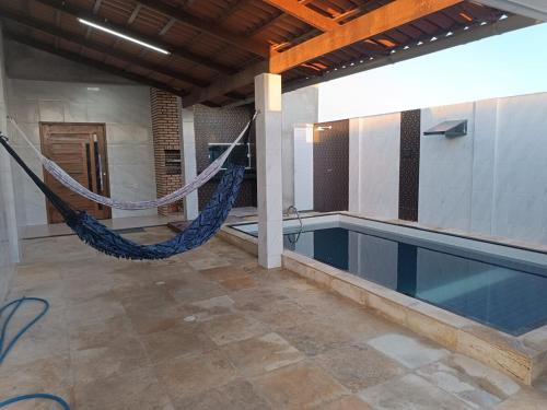 a swimming pool with a hammock in a house at Nova casa de praia na Caponga in Cascavel