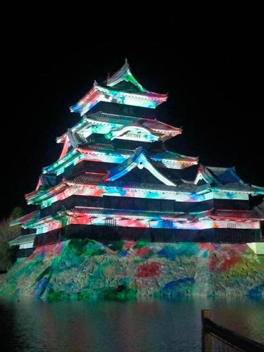 a large building with lights on it at night at Sakura in Matsumoto