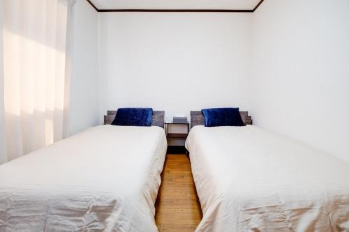two beds sitting next to each other in a room at Sakura in Matsumoto