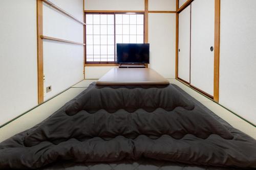 a bed in a room with a laptop on it at Sakura in Matsumoto