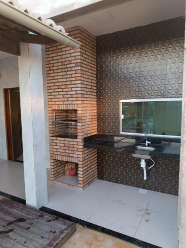 a room with a tv on a brick wall at Nova casa de praia na Caponga in Cascavel