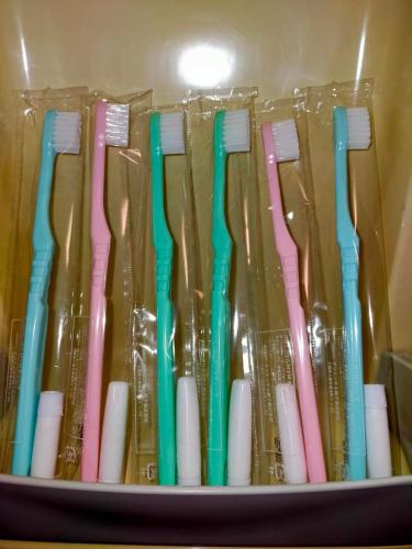 a group of different colored toothbrushes in a plastic container at Sakura in Matsumoto