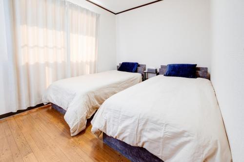 two beds sitting next to each other in a bedroom at Sakura in Matsumoto