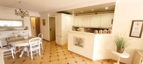 une cuisine et une salle à manger avec une table et des chaises dans l'établissement Superb Apt Great Comfort with Balcony & Pool, à Sainte-Maxime