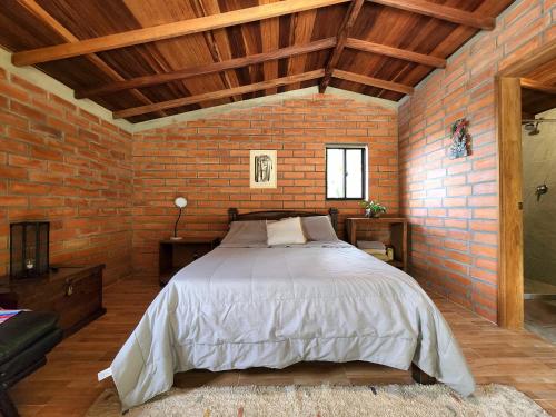 a bedroom with a large bed in a brick wall at Casa Nutabe - Casa de Campo en Girardota cerca a Medellín in Girardota