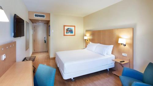 a bedroom with a large white bed and blue chairs at Sercotel Porta Barcelona in Sant Just Desvern