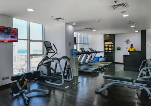 a gym with treadmills and exercise machines in a building at Swiss-Belhotel Seef Bahrain in Manama
