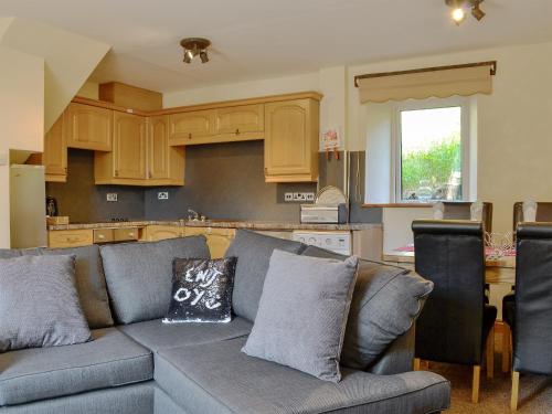 a living room with a couch and a kitchen at Brackendale Cottage - Uk1335 in Threlkeld