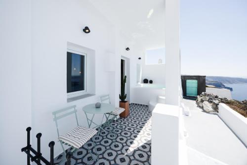 a white house with a view of the ocean at Surupo Suites in Imerovigli