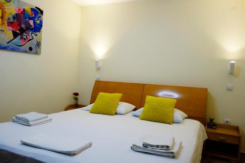 a bedroom with a bed with two yellow pillows at Villa Loop Beograd in Belgrade