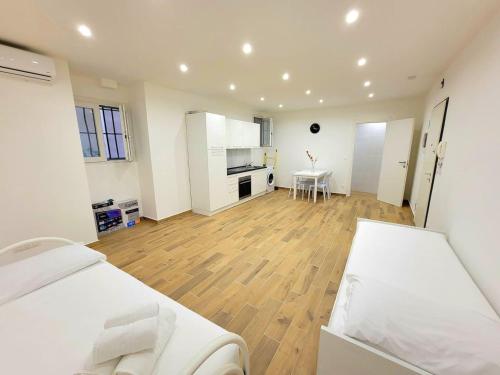 Cette grande chambre blanche dispose d'un lit et d'une cuisine. dans l'établissement Grande Bilocale in centro per famiglie-spiaggia, à Menton