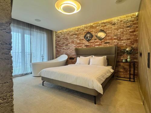 una camera da letto con un letto e un muro di mattoni di Premium Loft Apartment a Palanga