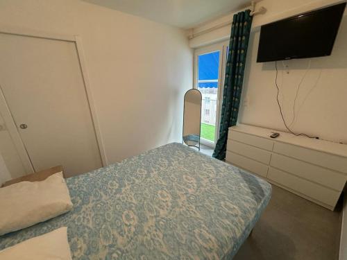 une chambre avec un lit, une télévision et une fenêtre dans l'établissement Bilocale con Ampia Terrazza, à Menton