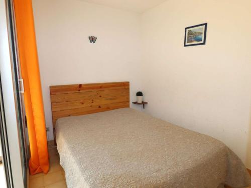 - une petite chambre avec un lit et une porte orange dans l'établissement Spacieux 2 pièces avec piscine, ascenseur, proche mer et commerces - FR-1-307-213, au Grau-du-Roi