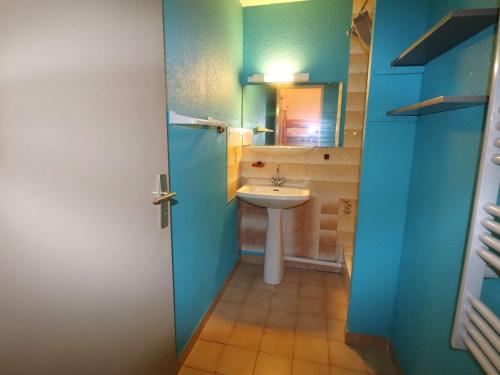 une salle de bain bleue avec un lavabo et des toilettes dans l'établissement Spacieux 2 pièces avec piscine, ascenseur, proche mer et commerces - FR-1-307-213, au Grau-du-Roi