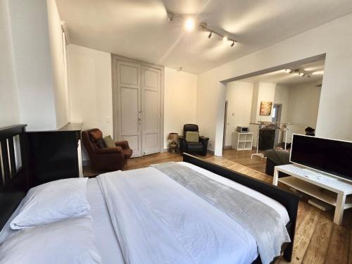 a bedroom with a large bed and a living room at Résidence Marianne 2 in Brussels